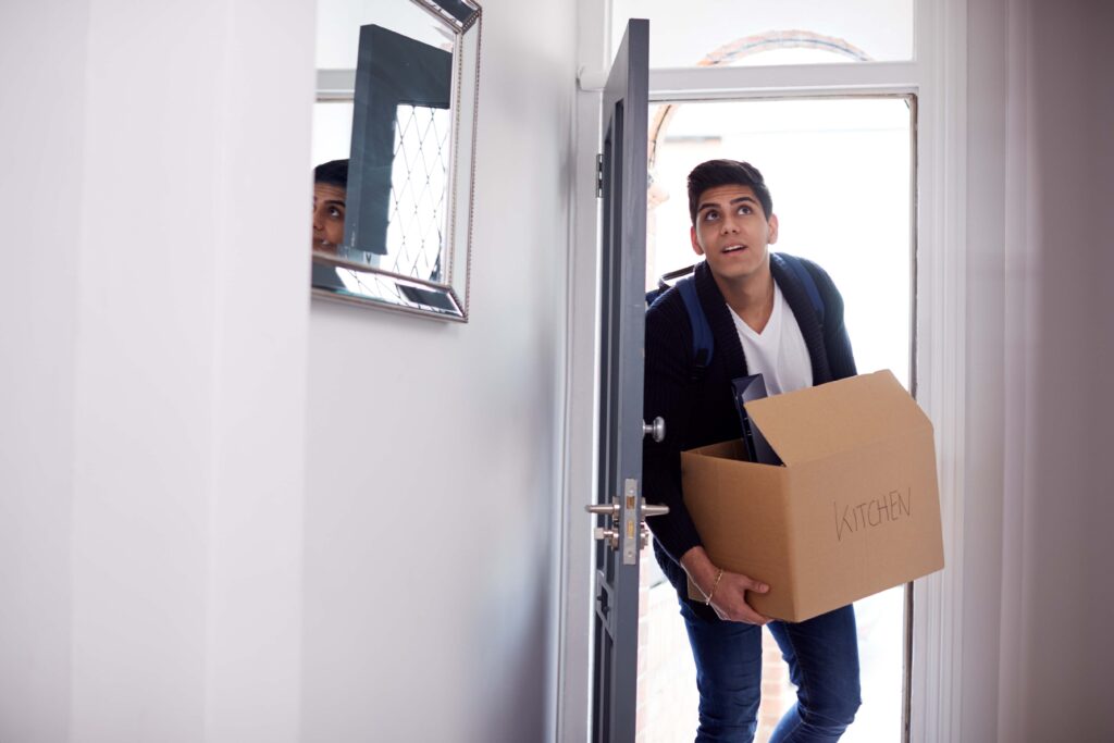 Young person with box moving house